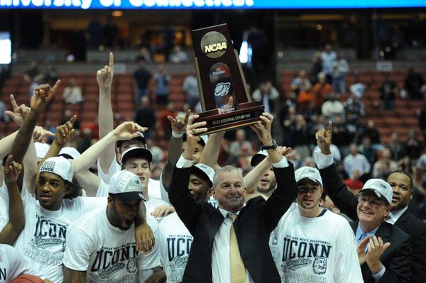 UConn Head Coach Jim Calhoun holds up the trophy